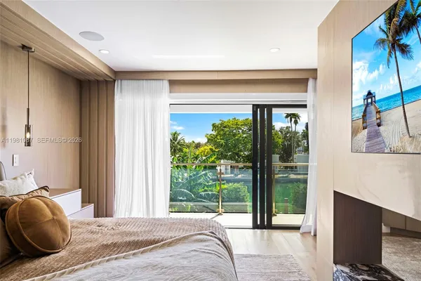 a bedroom with a bed and a flat tv screen next to a window