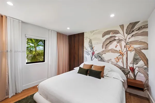 a bedroom with a large bed and a window