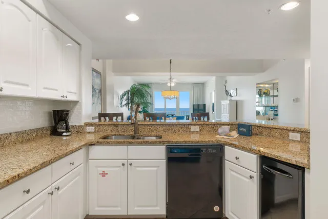 a kitchen with granite countertop kitchen island a sink appliances and cabinets