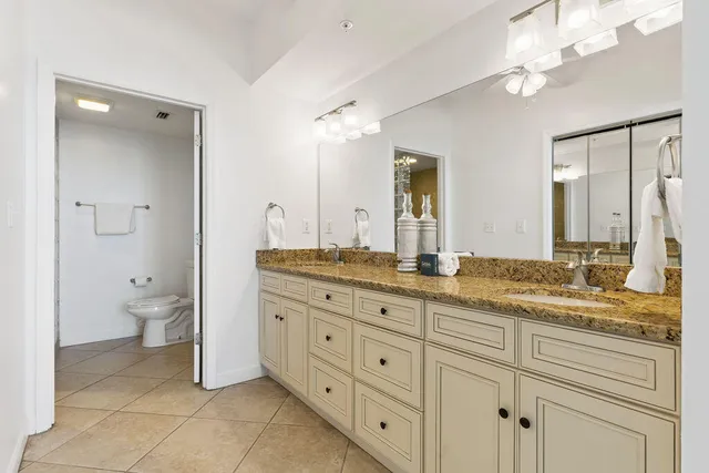 a spacious bathroom with a granite countertop sink mirror and toilet