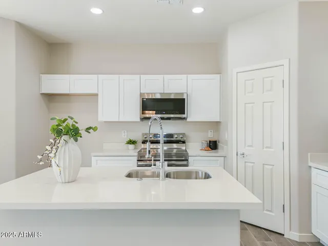 a kitchen with a sink a microwave and cabinets