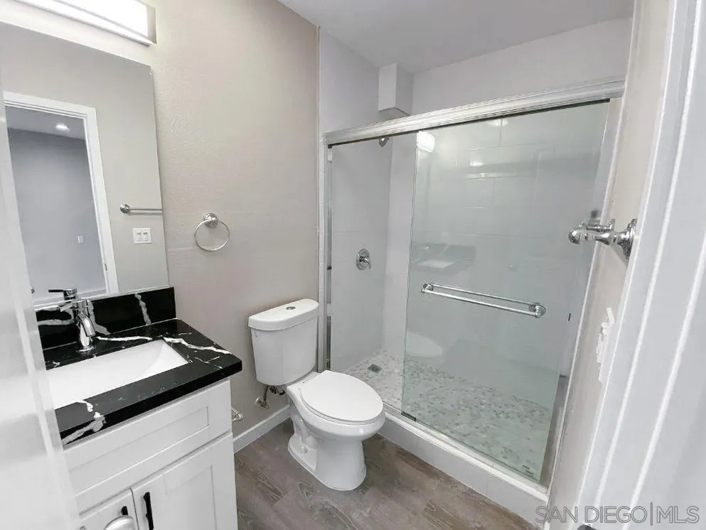 6497-99 Montezuma Road San Diego, CA 92115 - Photo 14 of 23 a bathroom with a toilet a sink and a shower