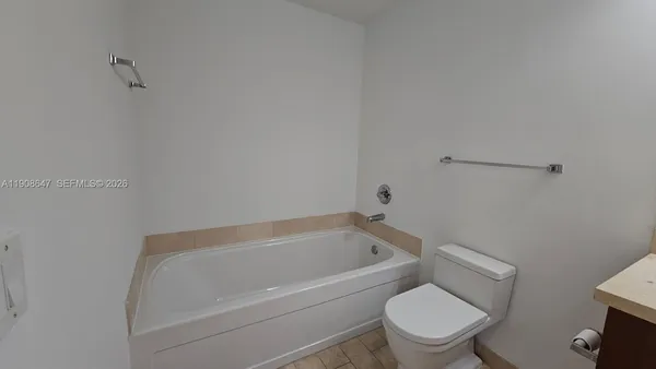a white bath tub sitting next to a white toilet
