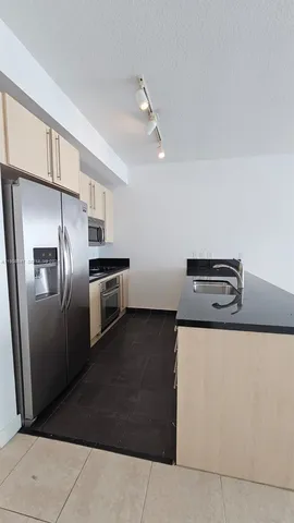 a kitchen with metallic refrigerator and stove