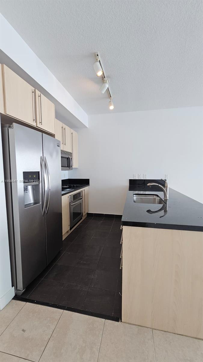 1111 Southwest 1st Avenue, Unit 2124N Miami, FL 33130 - Photo 3 of 34 a kitchen with metallic refrigerator and stove