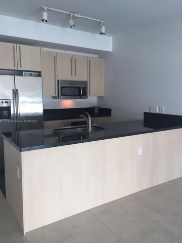 a kitchen with stainless steel appliances a sink and a refrigerator