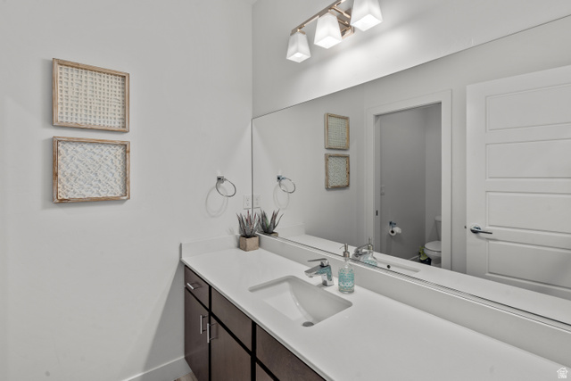 1122 South 1790th West, Unit 1 St. George, UT 84770 - Photo 23 of 37 Spacious vanity with an integrated rectangular sink, expansive mirror, and dark wood-finish cabinetry