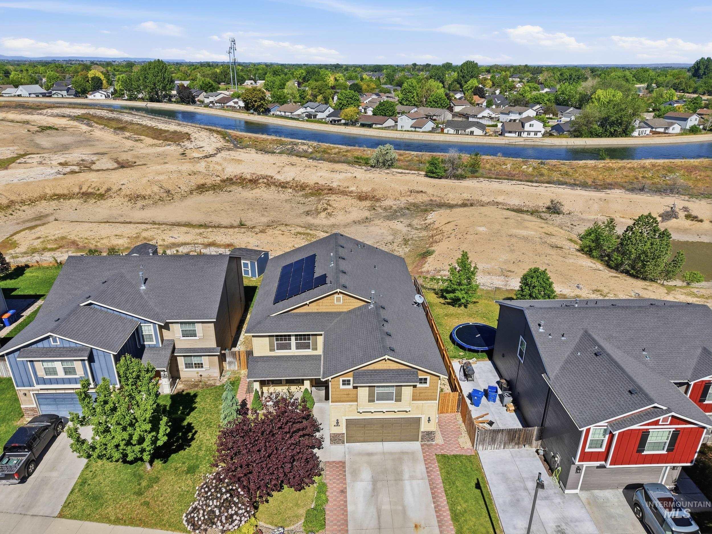 4855 South Chex Way Boise, ID 83709 - Photo 42 of 47 Two-story residence featuring a two-car garage, solar panels, and a landscaped front yard