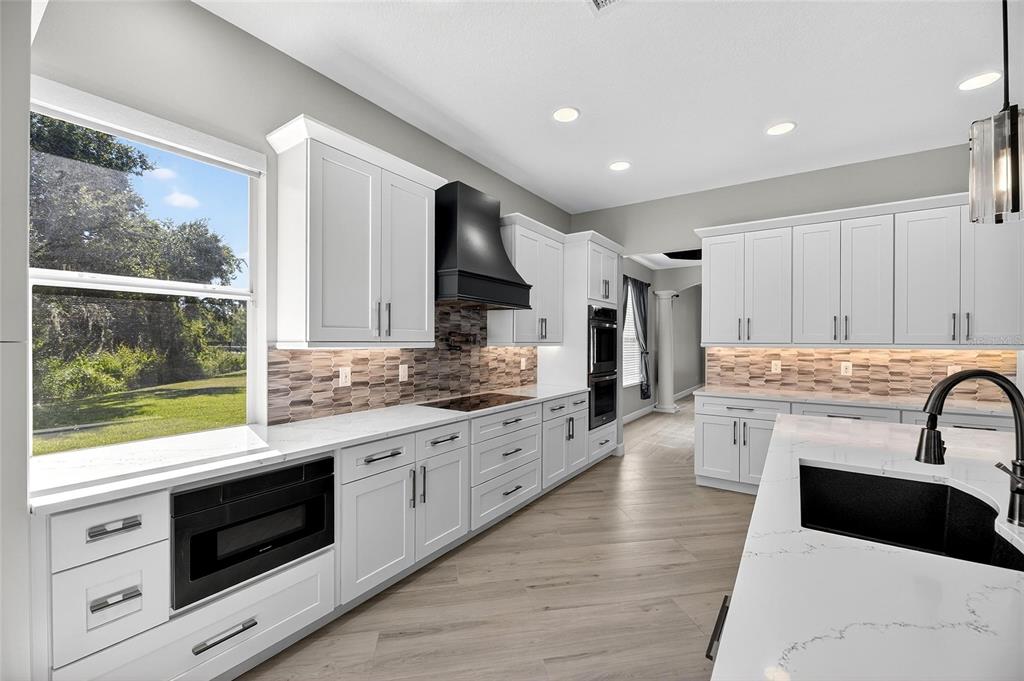 4310 70th Avenue East Ellenton, FL 34222 - Photo 14 of 97 a large kitchen with stainless steel appliances granite countertop a stove and a sink