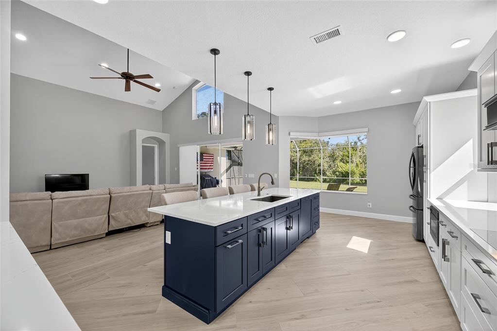 4310 70th Avenue East Ellenton, FL 34222 - Photo 15 of 97 a large kitchen with kitchen island a large counter space a sink a window and stainless steel appliances