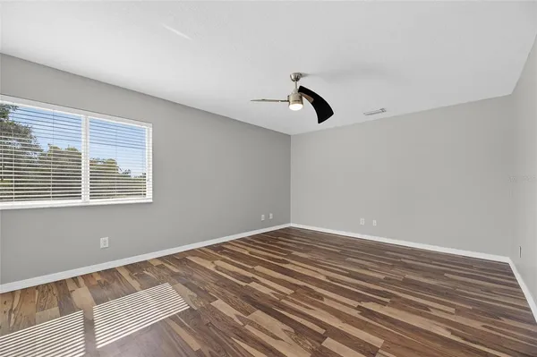 a view of an empty room with a chandelier fan
