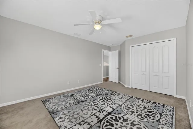 a view of an empty room with wooden floor and windows