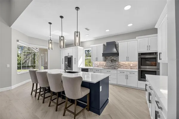 a large kitchen with stainless steel appliances granite countertop a stove and a sink