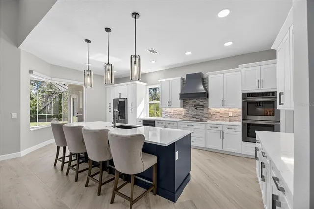 a large kitchen with stainless steel appliances granite countertop a stove and a sink
