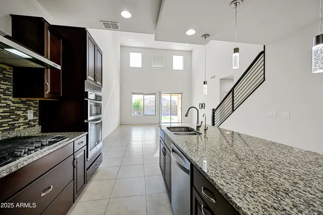 a kitchen with granite countertop a sink stove and refrigerator