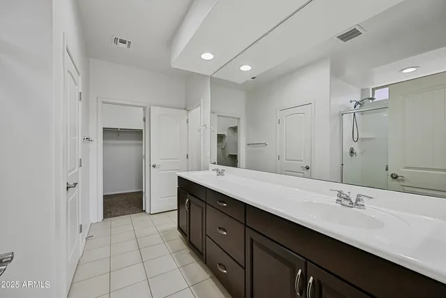 a spacious bathroom with a double vanity sink mirror and shower