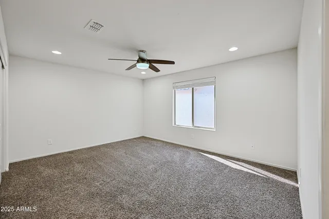 an empty room with a window and a ceiling fan