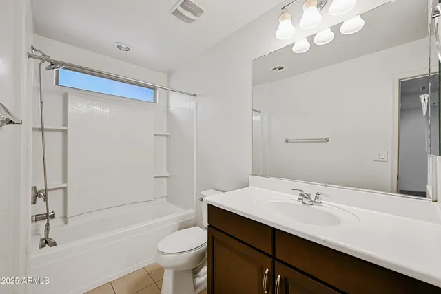 a bathroom with a sink a toilet a mirror and shower