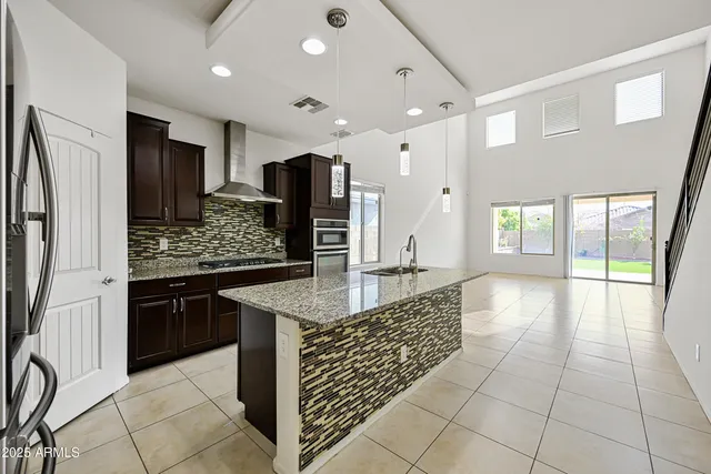 a kitchen with stainless steel appliances kitchen island granite countertop a refrigerator and a stove