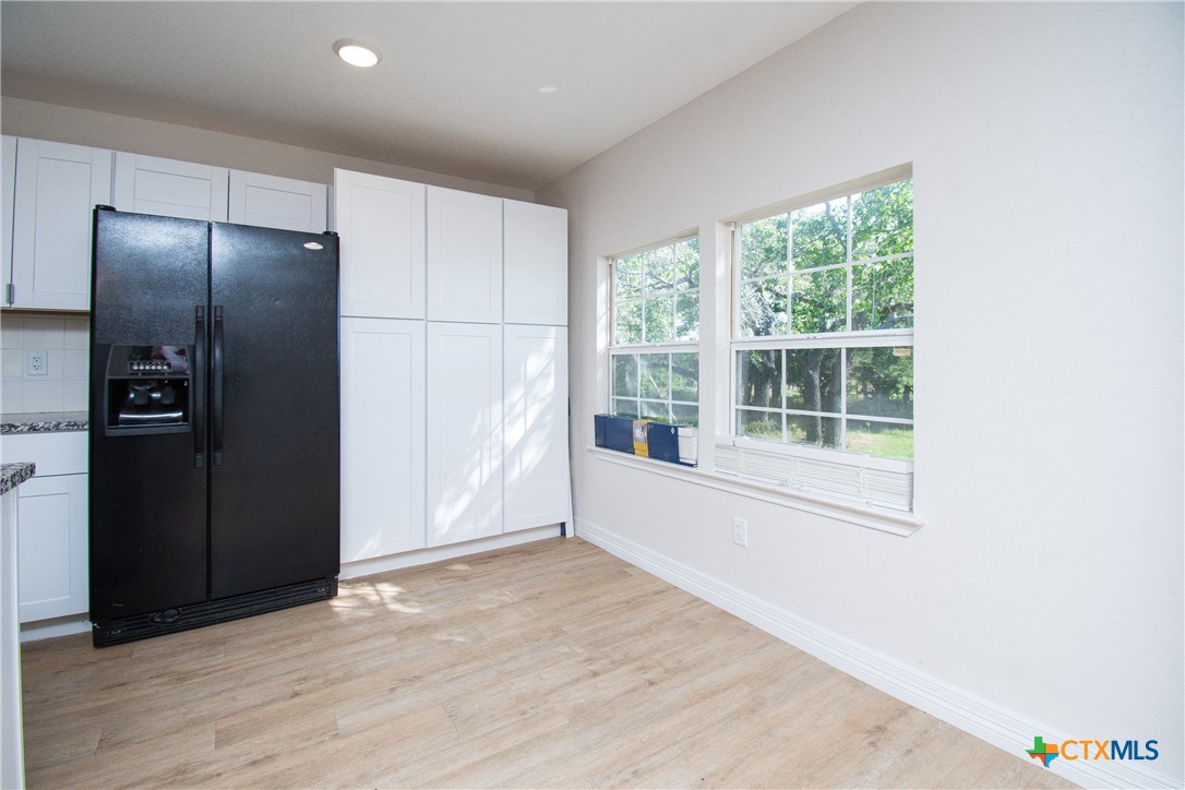 199 Apache Springs Road Briggs, TX 78608 - Photo 5 of 28 a view of an empty room with wooden floor and a window