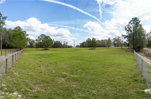 a view of a field with an trees in the background