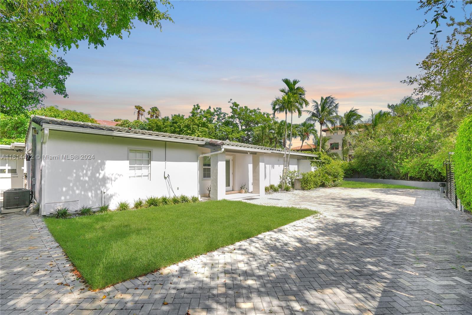 599 Glenridge Road Key Biscayne, FL 33149 - Photo 1 of 53 a front view of a house with a yard and garage