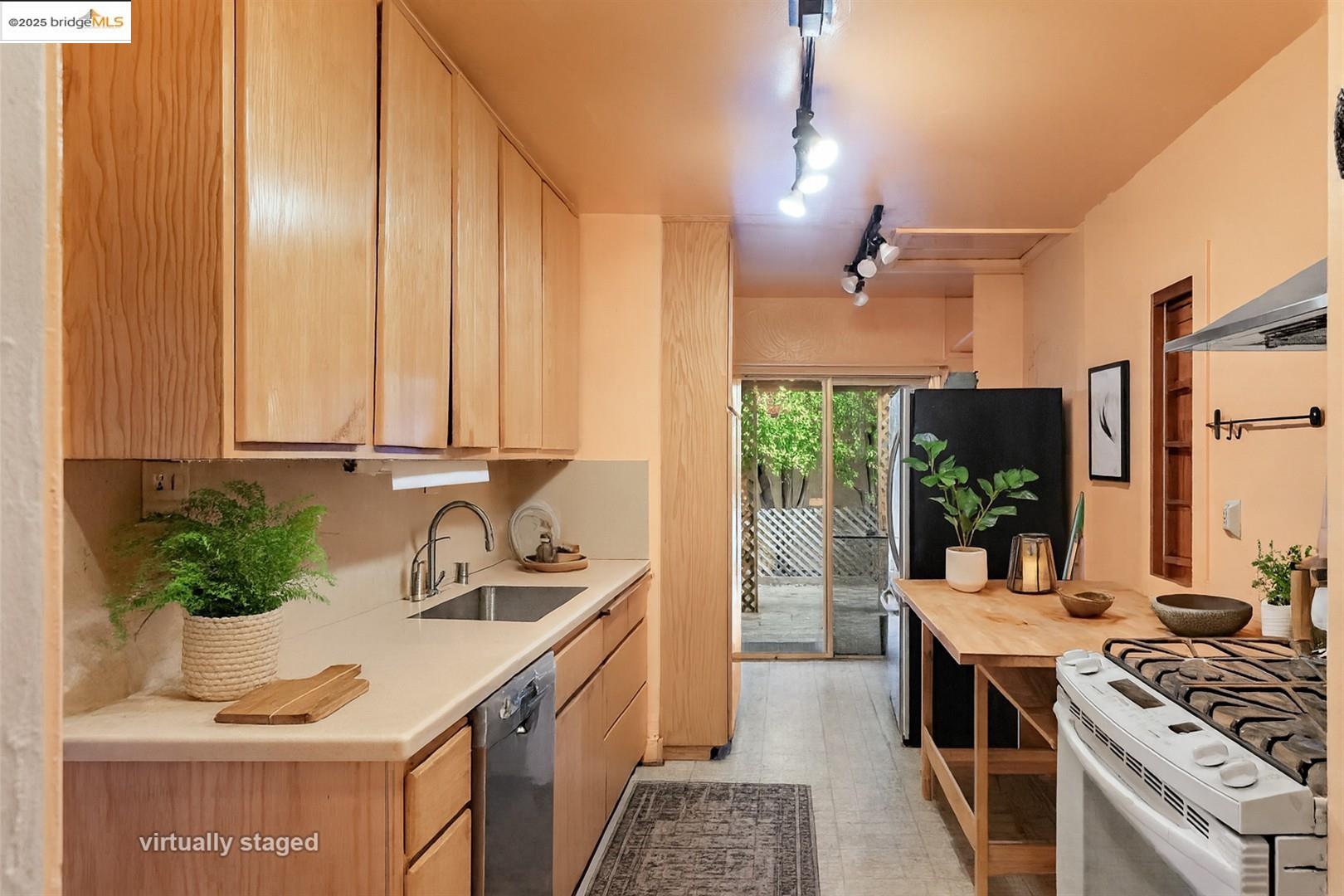 2201-2203 Spaulding Avenue Berkeley, CA 94703 - Photo 46 of 56 Kitchen with light brown cabinetry, gas range gas stove, track lighting, light countertops, and wall chimney range hood