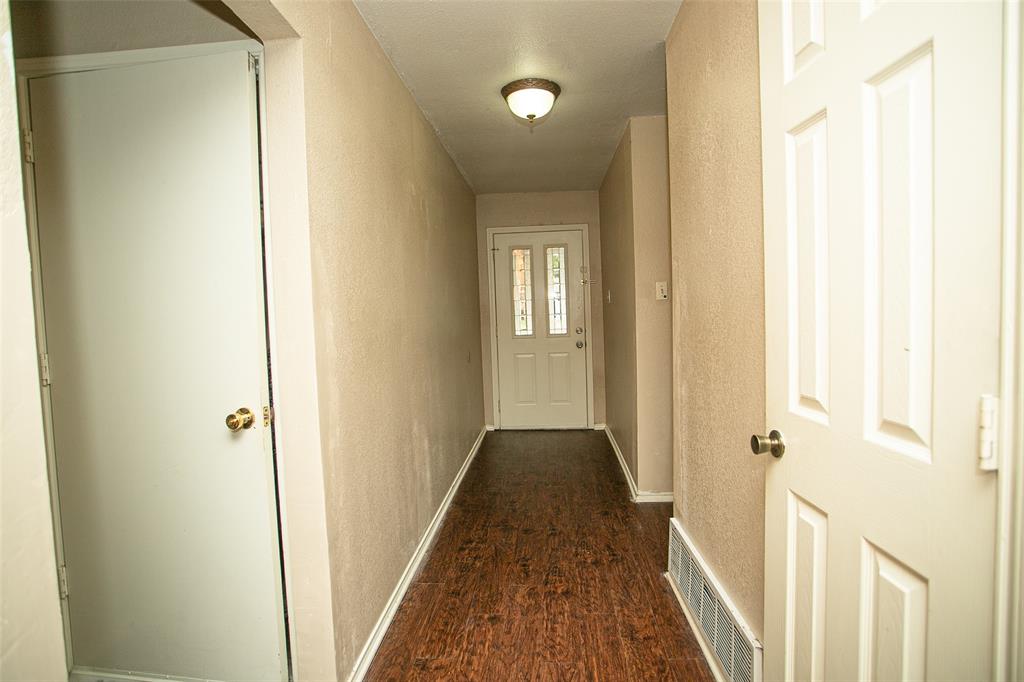 2019 West Nathan Lowe Road Arlington, TX 76017 - Photo 9 of 21 Neutral-toned room featuring a single window with blinds, wood-finish flooring, white trim, and an overhead flush-mount light fixture