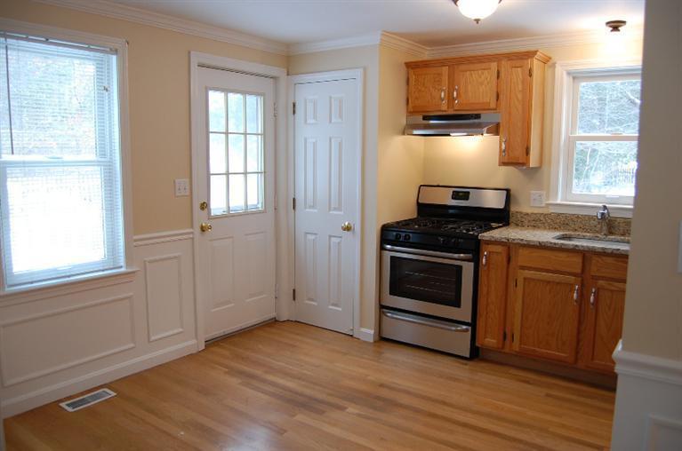 142 Skunknet Road Centerville, MA 02632 - Photo 3 of 35 a kitchen with granite countertop a stove and a refrigerator