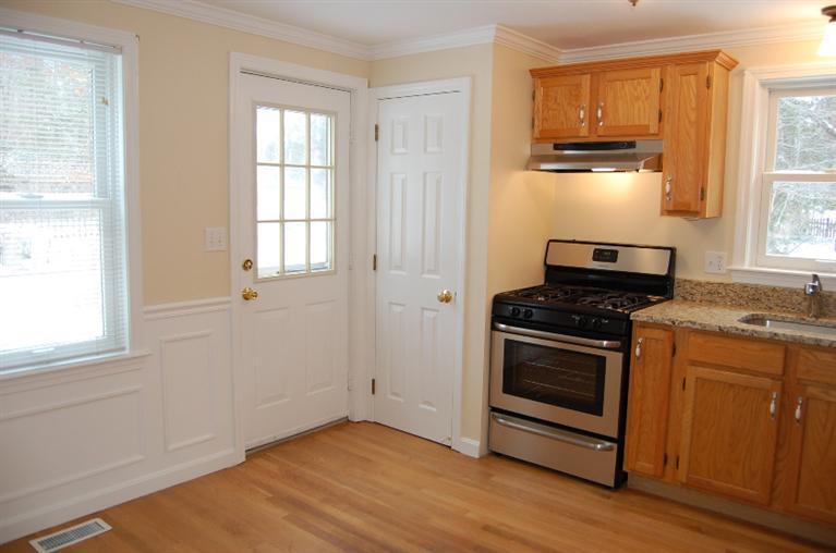 142 Skunknet Road Centerville, MA 02632 - Photo 6 of 35 a kitchen with granite countertop a stove and a refrigerator