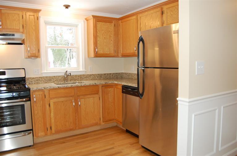 142 Skunknet Road Centerville, MA 02632 - Photo 8 of 35 a kitchen with stainless steel appliances granite countertop a refrigerator a sink and white cabinets with wooden floor