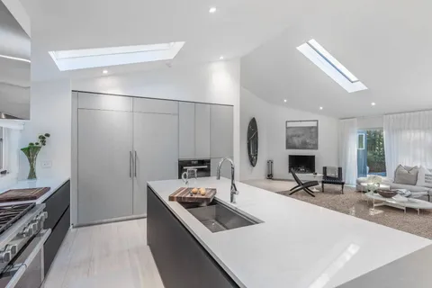a kitchen with a sink stove and wooden floor