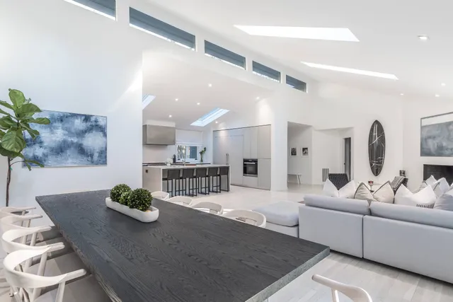 a living room with furniture kitchen view and a table