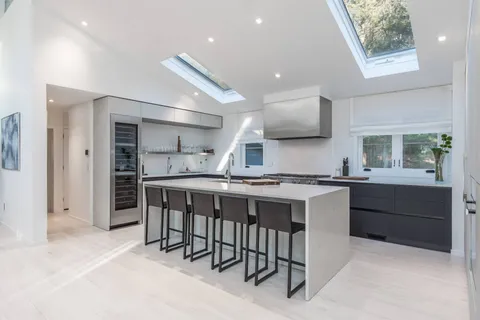 a kitchen with a sink and chairs