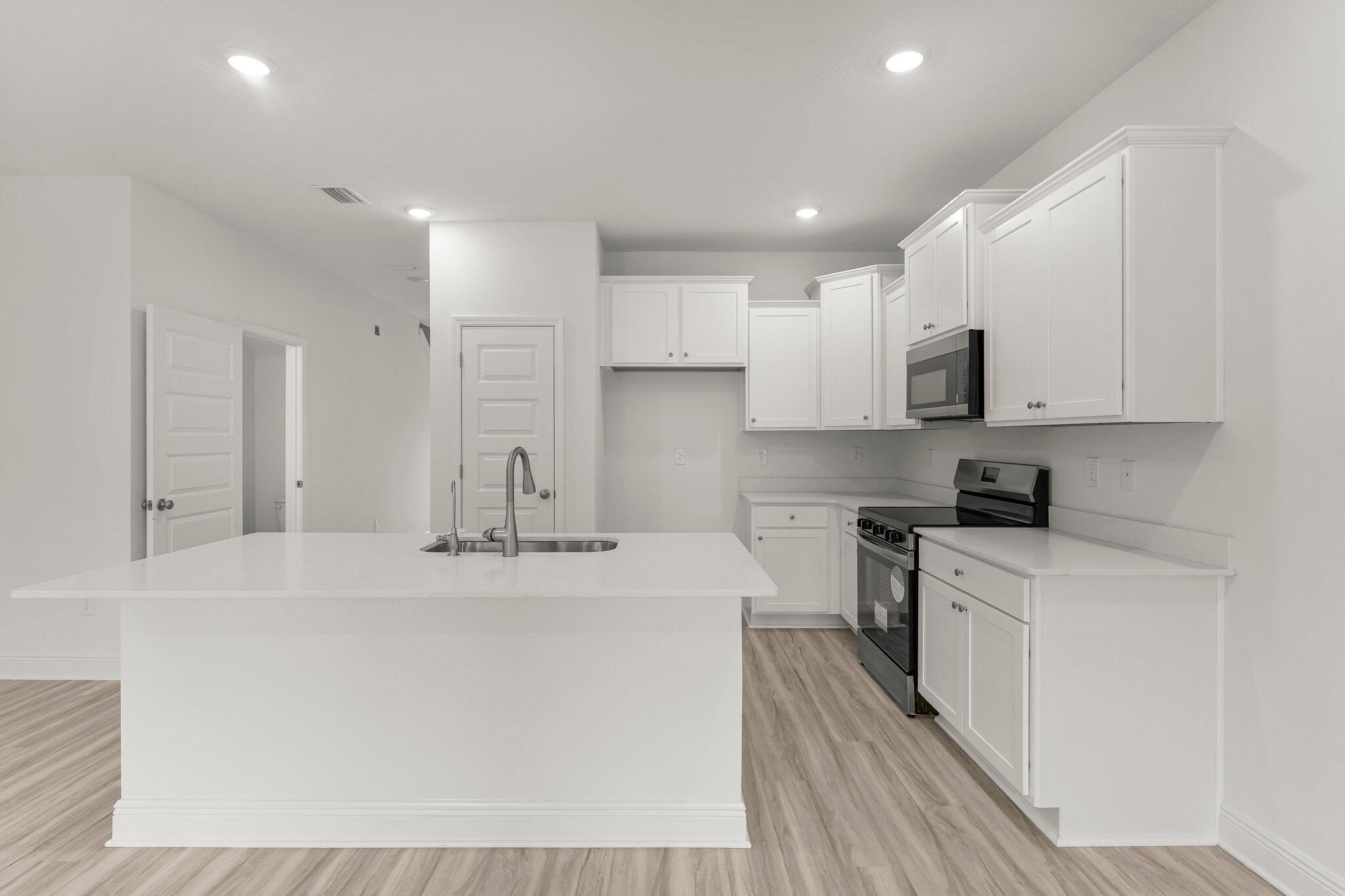 48 Hawk Street Santa Rosa Beach, FL 32459 - Photo 15 of 34 a kitchen with kitchen island white cabinets appliances and a sink