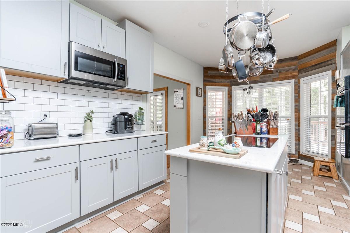 873 Blue Store Road Forsyth, GA 31029 - Photo 12 of 25 a kitchen with kitchen island granite countertop stainless steel appliances a sink stove and cabinets