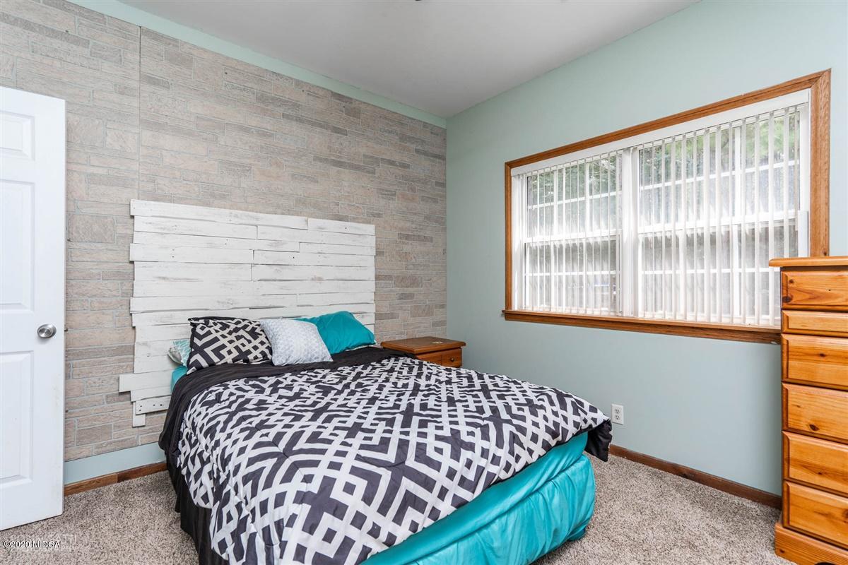 873 Blue Store Road Forsyth, GA 31029 - Photo 17 of 25 a bed sitting in a bedroom next to a window