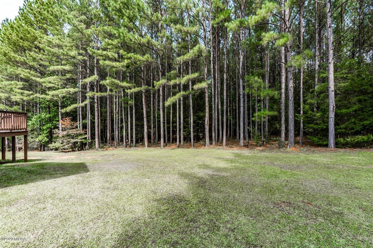 873 Blue Store Road Forsyth, GA 31029 - Photo 25 of 25 a view of a yard with large trees and a wooden fence