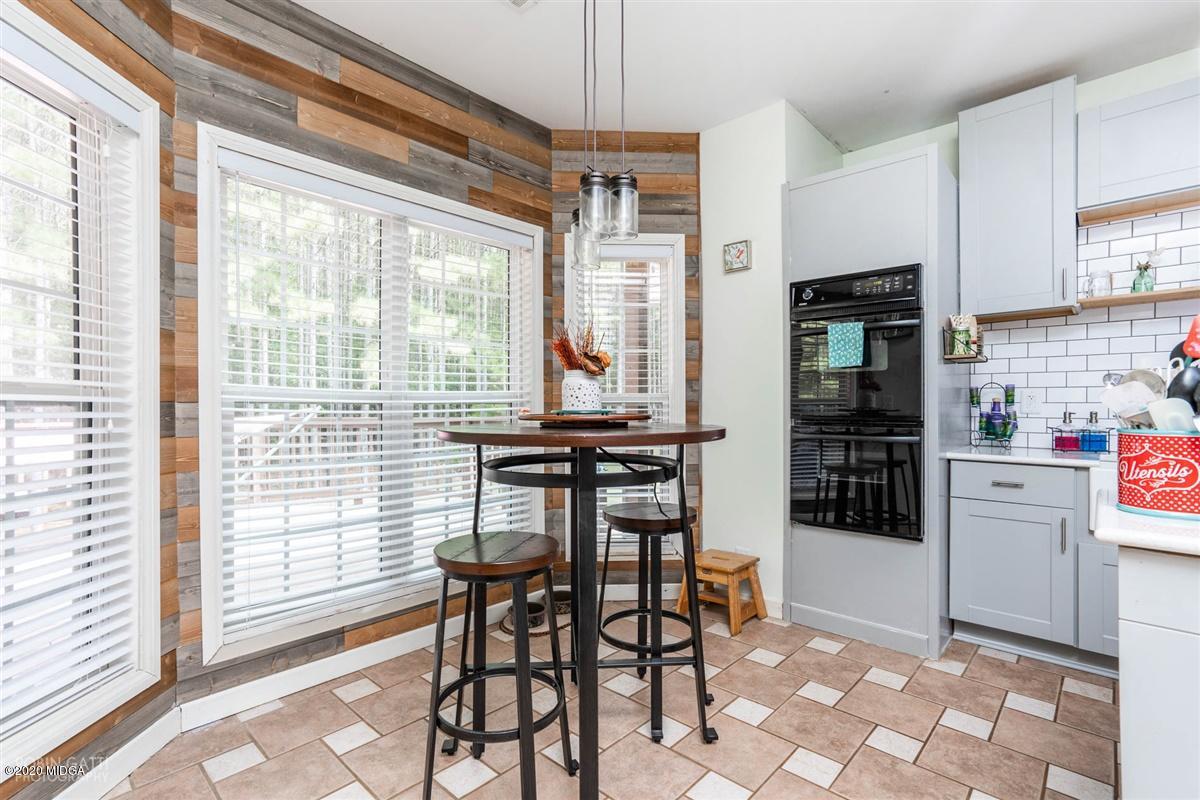 873 Blue Store Road Forsyth, GA 31029 - Photo 9 of 25 a dining room with stainless steel appliances a dining table chairs and chandelier