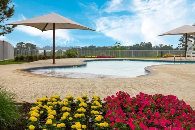 a view of a house with pool and chairs