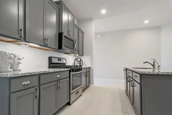 a kitchen with stainless steel appliances granite countertop a sink stove and cabinets