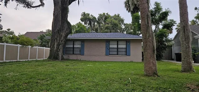 a view of a house with a yard and tree