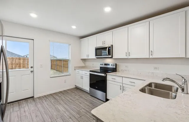a kitchen with granite countertop white cabinets and white appliances