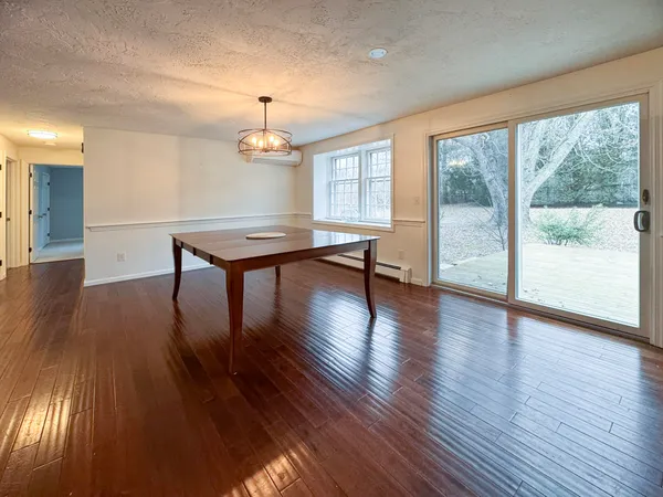 a room with wooden floors table and chairs