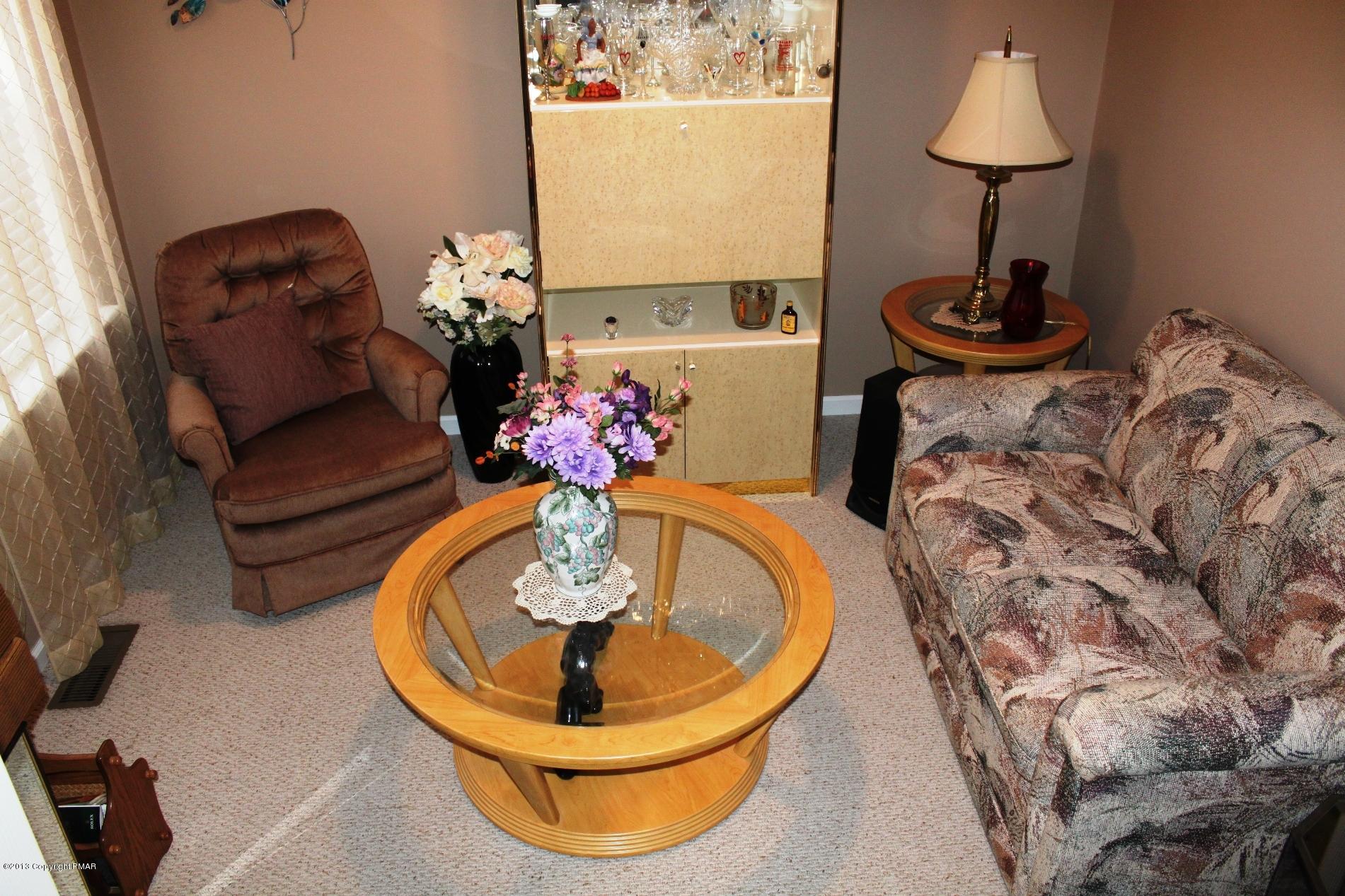 128 Ruth Drive Cresco, PA 18326 - Photo 10 of 28 a living room with furniture and a chandelier