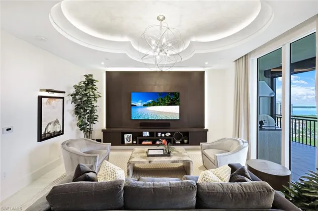 a living room with furniture a chandelier and a flat screen tv