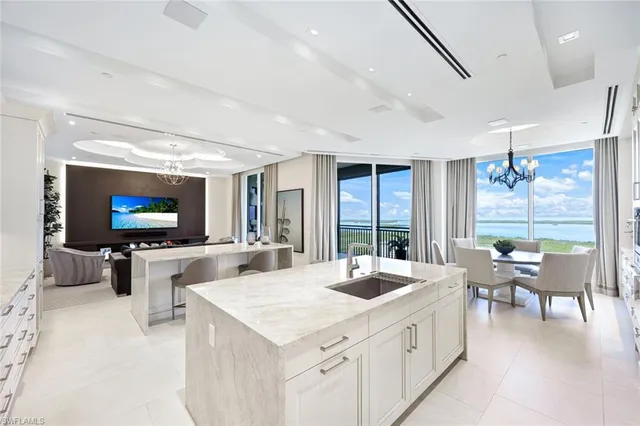 a large white kitchen with a large window and furniture