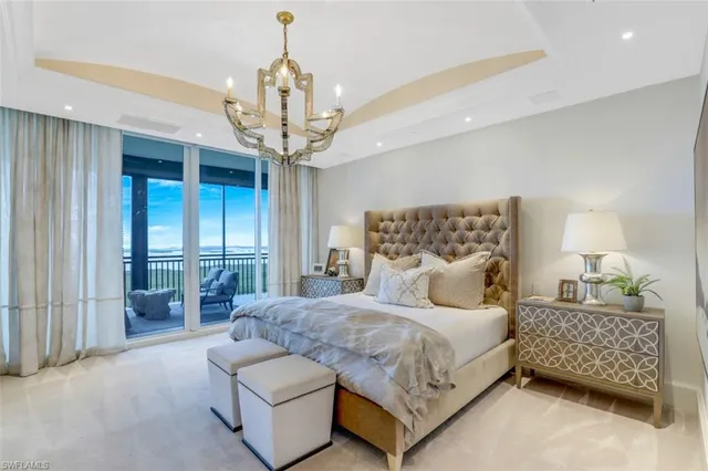 a bedroom with a bed chandelier and window