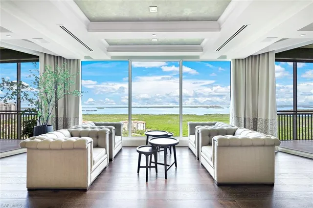 a living room with furniture and floor to ceiling windows