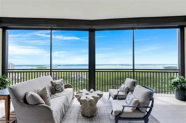 a living room with furniture and a floor to ceiling window